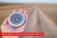 Foto: eine Hand hält einen Kompass, im Hintergrund ist ein Feldweg zu sehen. Text: "Nicht allein in herausfordernden Zeiten"