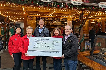 Auf dem Fürther Weihnachtsmarkt übergaben Ronald und Petra Morawski (rechts) den Spendenscheck über 3000 Euro an Andrea Engelhardt (l.) und Waltraud Heiter (2.v.l.), die sich beide ehrenamtlich beim Herzenswunschmobil engagieren, sowie BRK-Kresigeschäftsführer Thomas Leipold (Mitte).