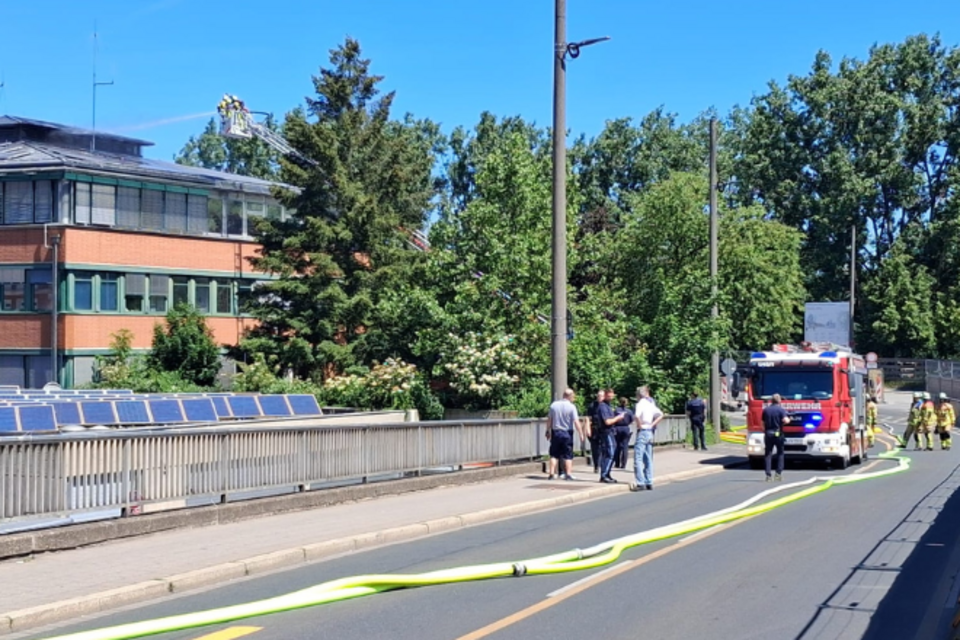 Brand BRK-Haus Fürth BRK Gebäude, davor ein Feuerwehrfahrzeug und Feuerwehrkräfte, die den Dachstuhl löschen