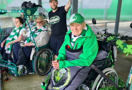 Ein älterer Herr mit Fankleidung der SpvGG Fürth sitzt in einer Rikscha.