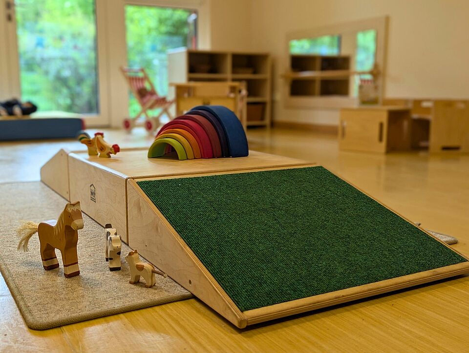 Gruppenraum einer Krippengruppe mit Spielzeug aus Holz